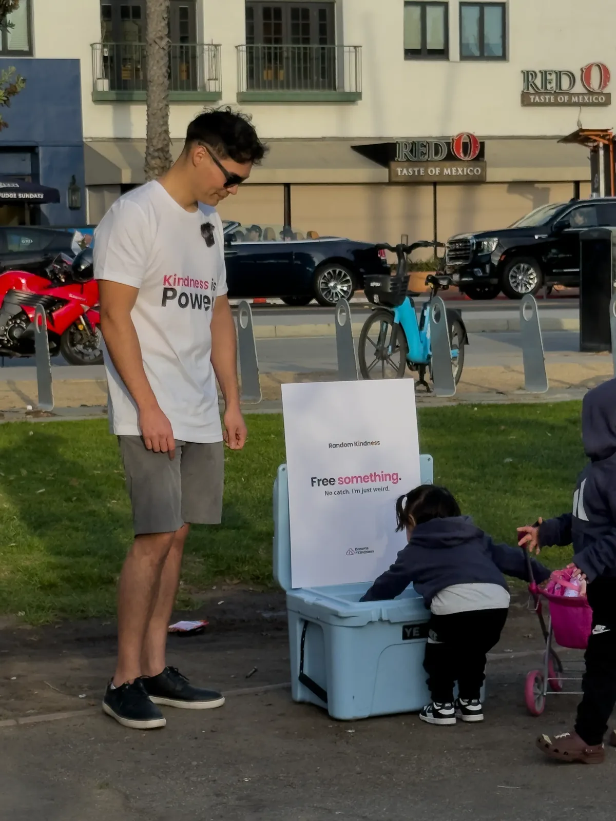 A child takes a free item from the Dreams of Kindness cooler at a Random Kindness street activation in Southern California