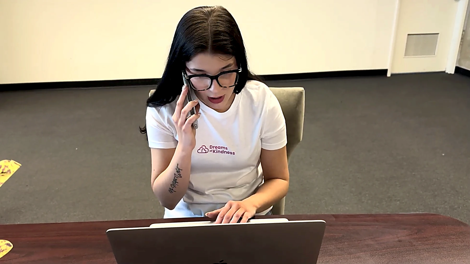 A Dreams of Kindness team member on a call at her laptop